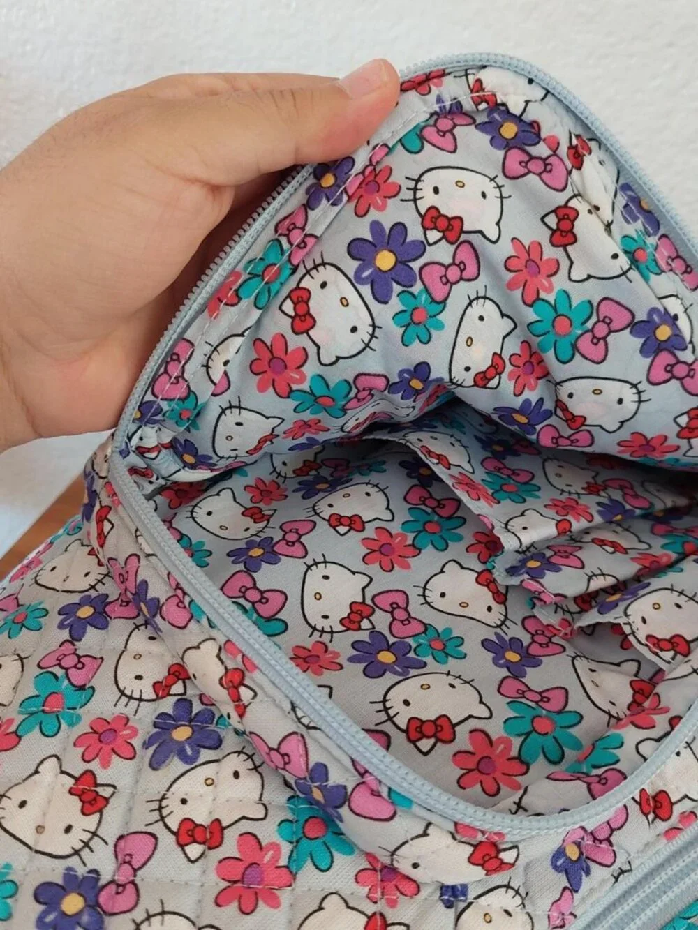vera bradley Hello Kitty sling bag with repeating Hello Kitty faces and flowers